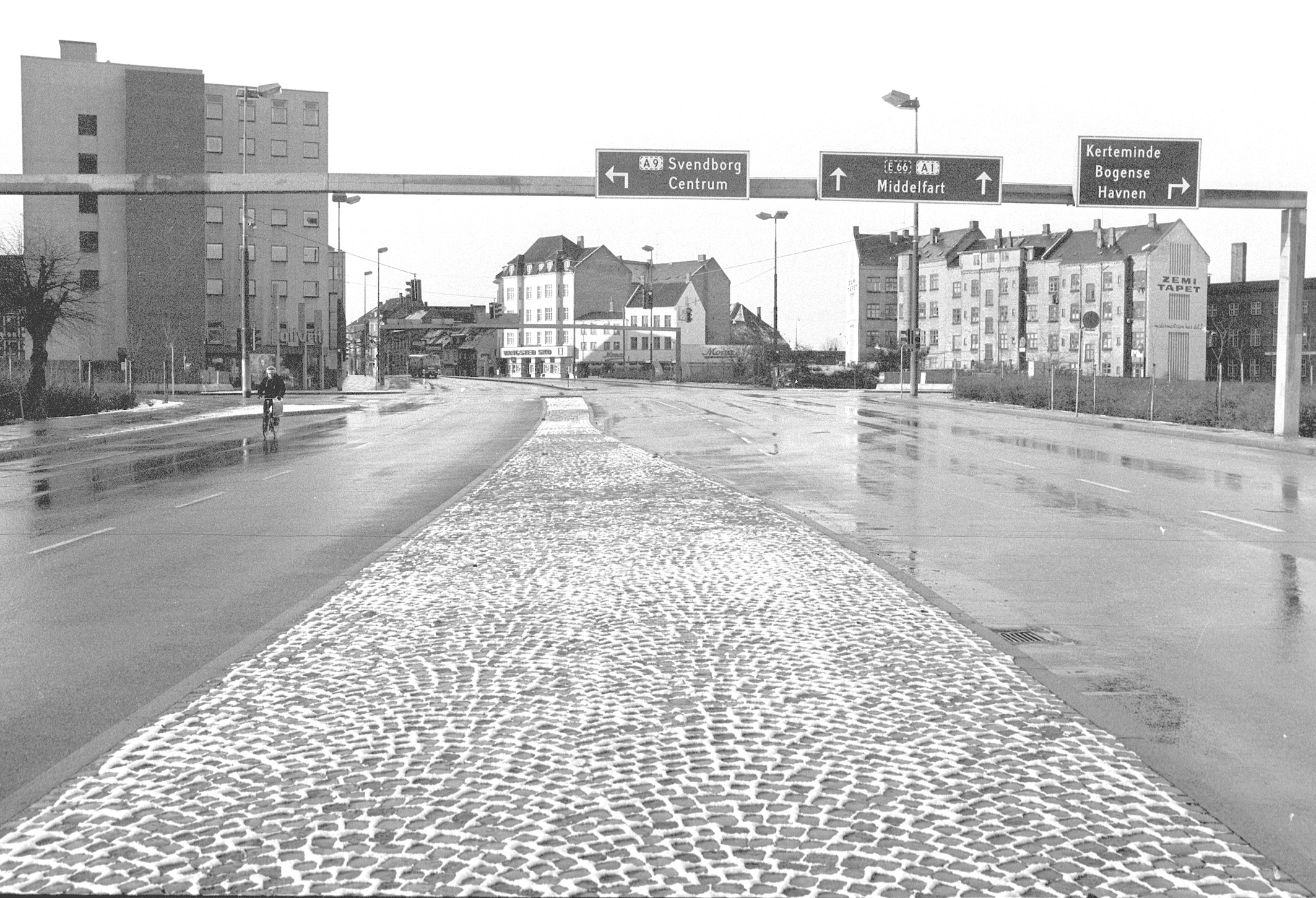 Sparsom søndagstrafik på Hans Mules Gade, den 25. november 1973. De bilfri søndage lagde gaderne øde for biltrafik, men de få tilladte motorkøretøjer, kunne stadig irritere de stakkels odenseanere på en stille søndag. // Fyens Stiftstidendes pressefotosamling, Odense Stadsarkiv 