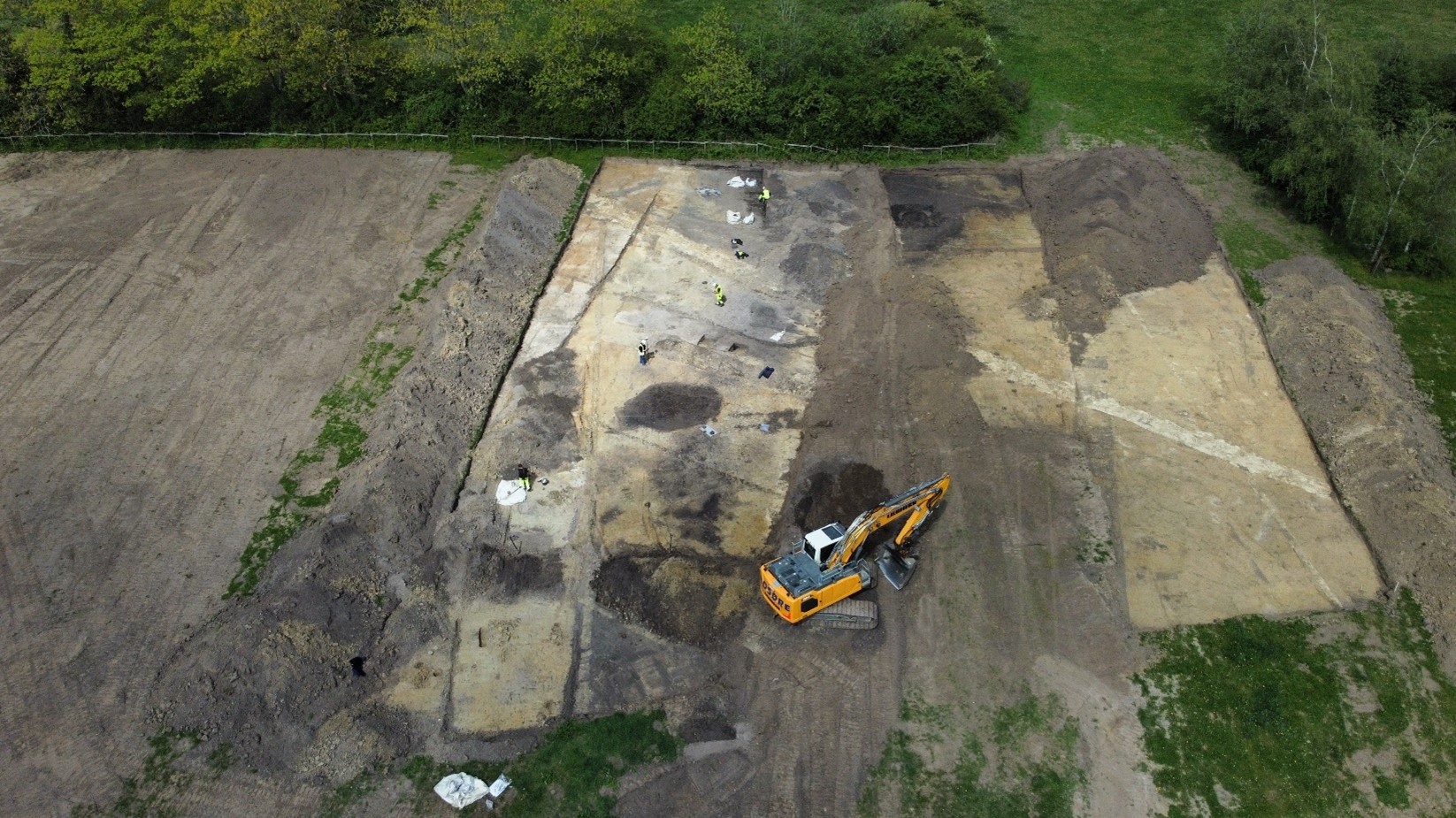 Udgravningen set fra luften. Kulturlagene fra stenalderen ses øverst i billedet, hvor arkæologerne arbejder.