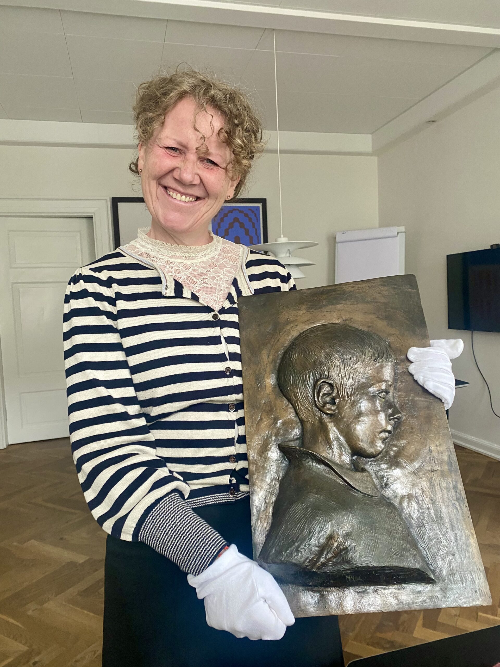 Museumsinspektør Ida-Marie Vorre med Anne Marie Carl-Nielsens relief af sin yngste søn